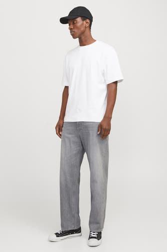 Jean décontracté gris clair de JACK & JONES JEANS INTELLIGENCE, avec une coupe décontractée et porté avec un T-shirt blanc et un chapeau noir.