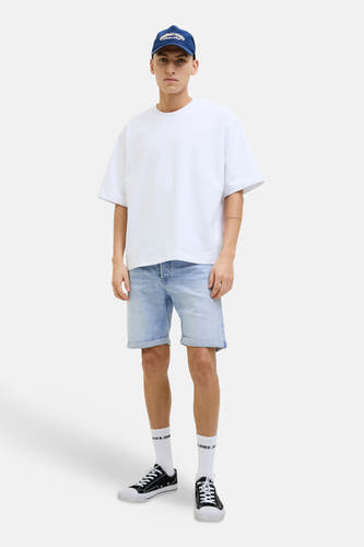 Lichtblauwe denim jeansshort van JACK & JONES JEANS INTELLIGENCE, met opgerolde zoom, gecombineerd met een wit T-shirt en zwarte sneakers.