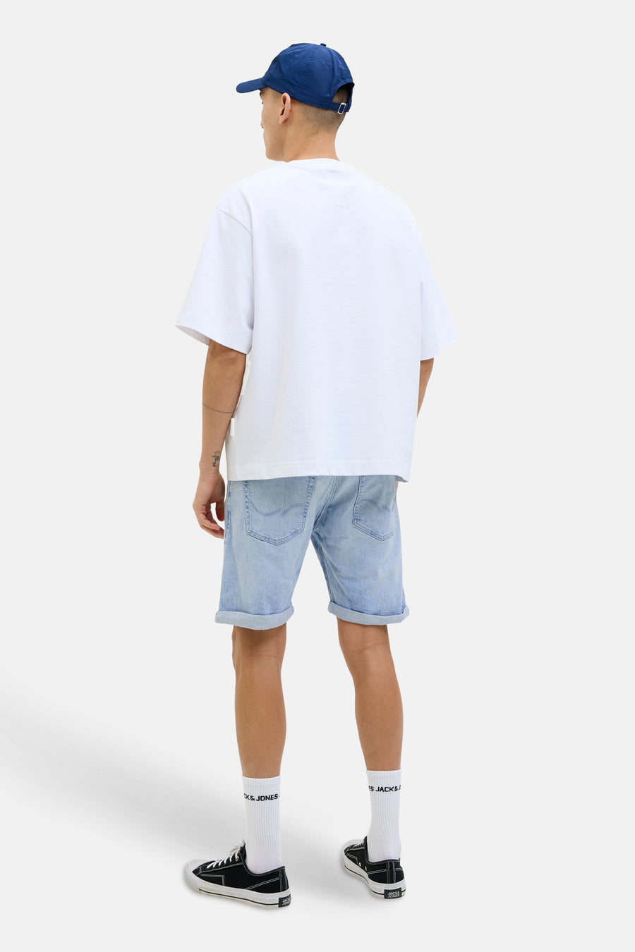 Short en jean en denim bleu clair de JACK & JONES JEANS INTELLIGENCE, avec ourlets retroussés, combiné avec un t-shirt blanc et des baskets noires.