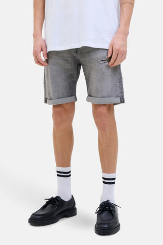 Jean court en denim gris moyen de JACK & JONES JEANS INTELLIGENCE, avec des poches rabattues et des chaussettes blanches à rayures noires.