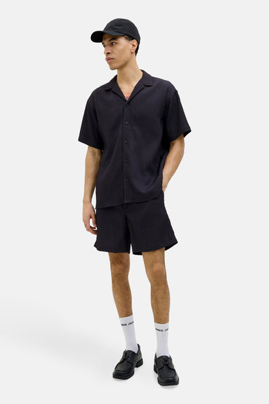 Short noir de JACK & JONES JEANS INTELLIGENCE, porté avec un t-shirt coordonné, des chaussettes et des chaussures.