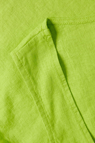 Close-up van een groene linnen stof met stiksels.
