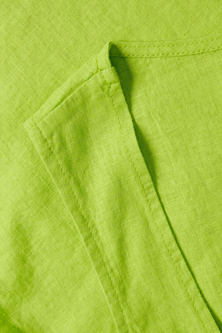 Close-up van een groene linnen stof met stiksels.
