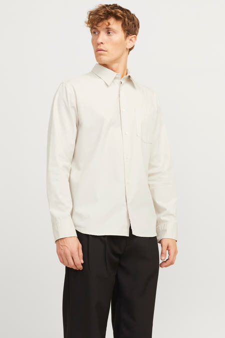 Chemise écru à longues manches de PREMIUM by JACK & JONES, portée avec un pantalon noir et des chaussures.