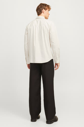 Chemise écru à manches longues de PREMIUM by JACK & JONES, vue de derrière, associée à un pantalon noir large et des chaussures noires.