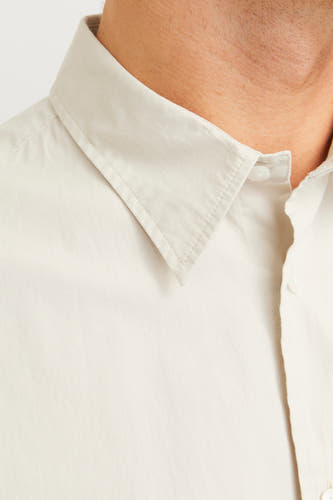 Chemise écru de couleur de longues manches par PREMIUM by JACK & JONES, avec un col pointu et une fermeture à boutons.