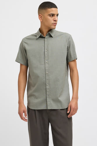 Kaki overhemd met korte mouwen van PREMIUM BLUE by JACK & JONES, met een subtiele textuur, gedragen met een donkere broek.
