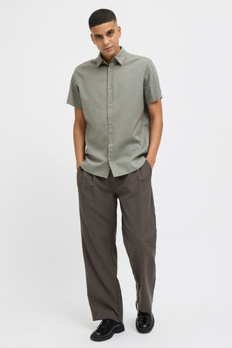 T-shirt kaki à manches courtes de PREMIUM BLUE par JACK & JONES, avec une subtile texture, porté avec un pantalon foncé.
