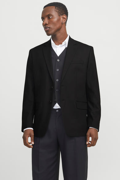 Blazer noir de PREMIUM par JACK & JONES, porté sur une chemise blanche et un gilet sombre, motif uni.