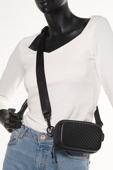 Sac à dos noir d'ACCESSORIES BY JACK & JONES, avec des bretelles diagonales et une bretelle d'épaule noire, porté par un mannequin avec un t-shirt blanc et des jeans.