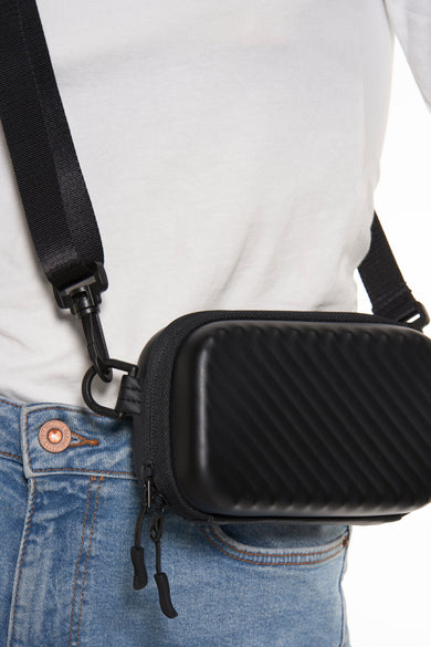 Sac à dos noir d'ACCESSORIES BY JACK & JONES, avec un motif rayé diagonal, porté sur un T-shirt blanc et des jeans bleus.