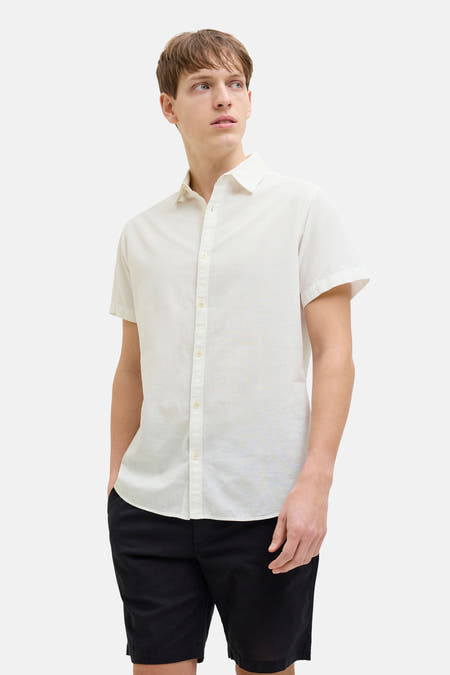 Chemise blanche à manches courtes de JJREBEL, portée avec des short noirs.