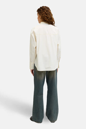 Chemise rayée jaune à manches longues de JJXX, vue de derrière avec un pantalon de jeans large.