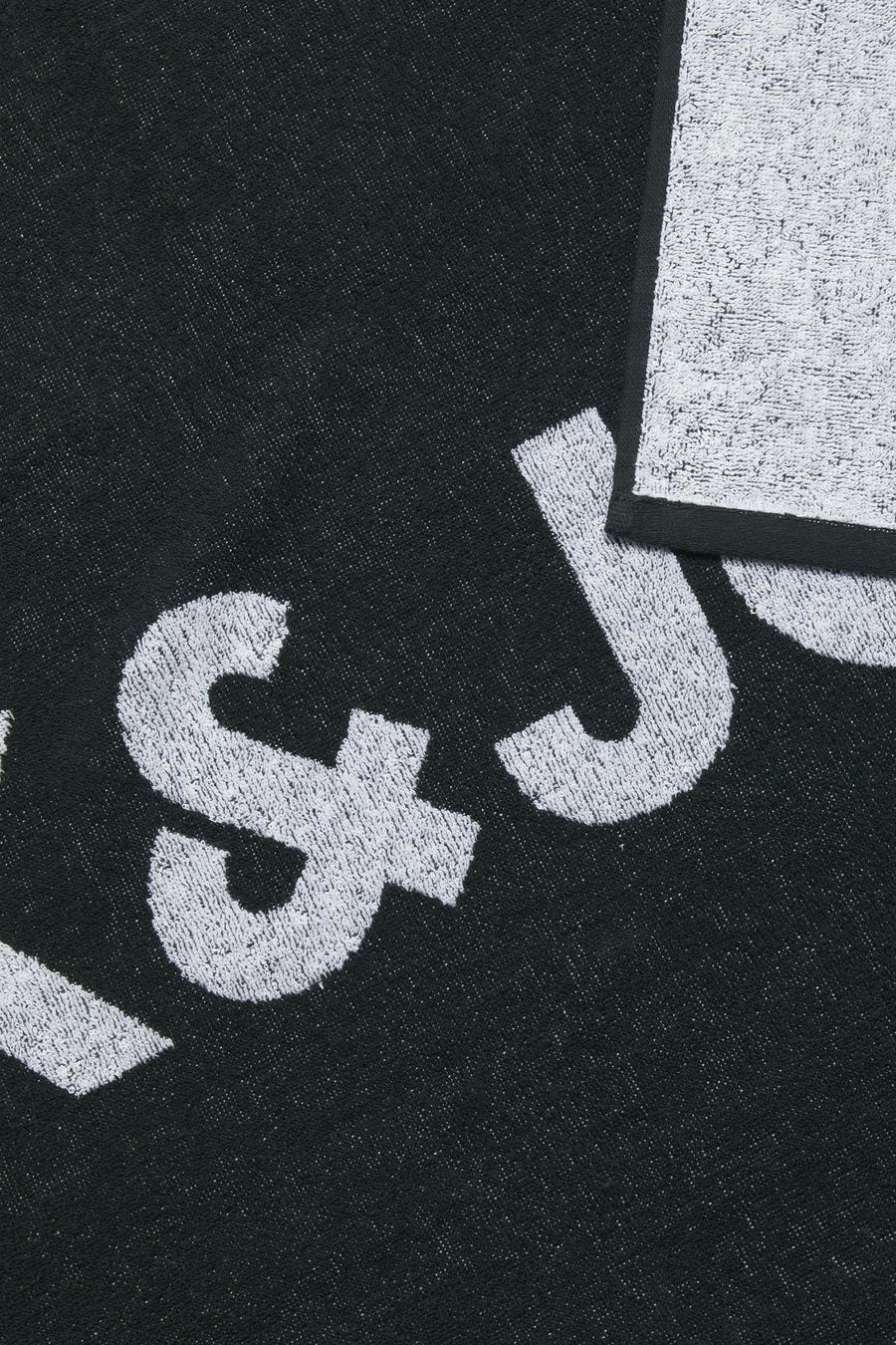 Linge de plage noir ACCESS ACCESSORIES BY JACK & J, avec une imprimé logo blanc et et bord contrastant.