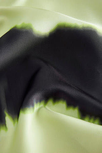 Blouse verte de JJXX avec des détails peints en noir et des plis subtils dans le tissu.