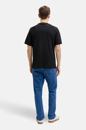 Zwart T-shirt met korte mouwen van JJREBEL, gedragen met blauwe jeans en witte sneakers, gezien van achteren.
