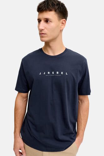 T-shirt bleu à manches courtes de JJREBEL, design simple porté par un modèle avec un pantalon beige.