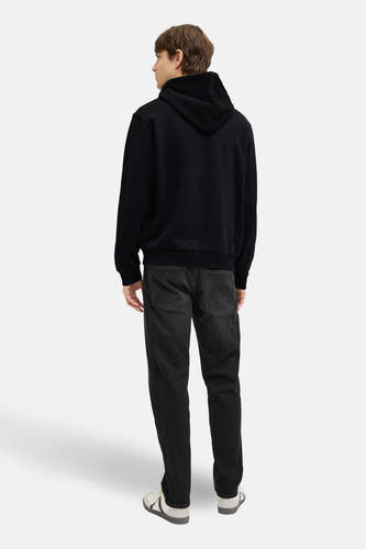 Sweat-shirt noir à capuche de JJREBEL, vu de dos, combiné avec un jean foncé et des baskets basses.