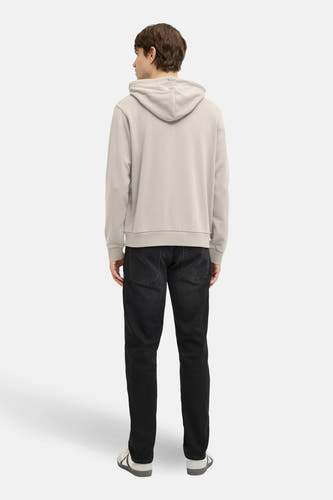 Pull beige à capuche JJREBEL, vu de dos, avec un jean foncé et des baskets blanches.