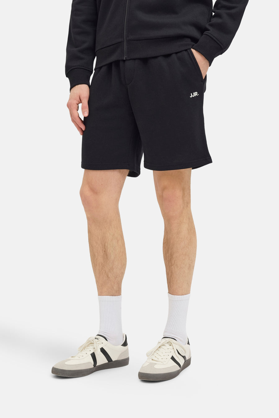 Short noir de JJREBEL, avec une coupe décontractée, associé à des chaussettes blanches et des baskets crème.