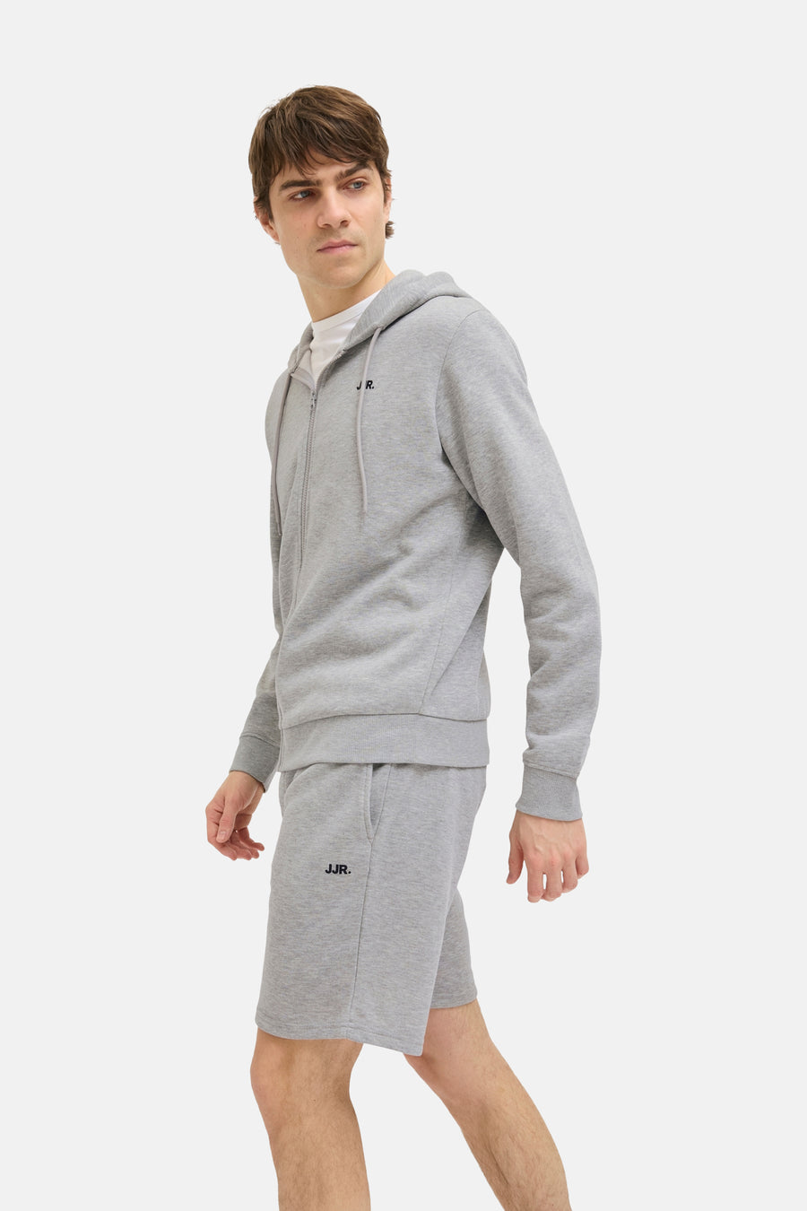 Short gris de JJREBEL, avec logo sur la jambe, porté avec une hoodie et un T-shirt blanc.