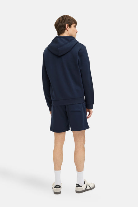 Short bleu foncé de JJREBEL, avec des chaussettes et des chaussures blanches, vue de dos.