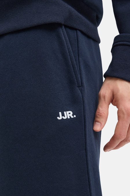Short bleu marine de JJREBEL, avec poche et logo blanc sur la jambe.