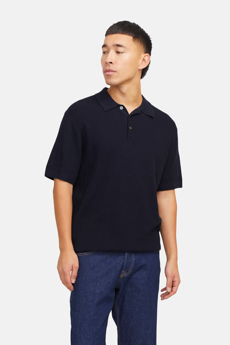 Polo bleu avec manches courtes de PREMIUM by JACK & JONES, porté avec des jeans et des chaussures marron.