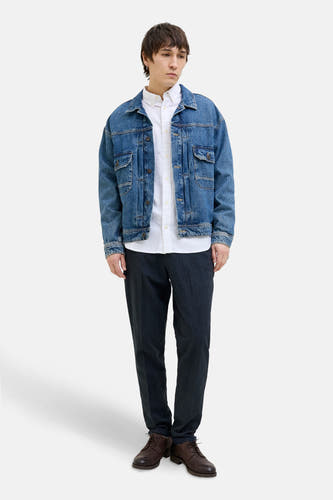 Jean chino bleu de JACK & JONES JEANS INTELLIGENCE, associé à une chemise blanche, un manteau en denim et des chaussures brunes.