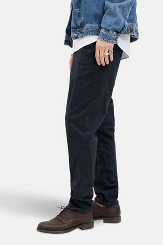 Jean chino bleu de JACK & JONES JEANS INTELLIGENCE, avec des chaussures en cuir marron et un blouson de travail, vue latérale.