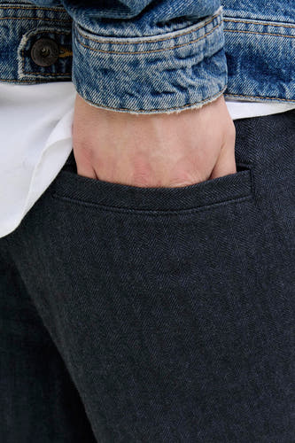 Jean chino bleu de JACK & JONES JEANS INTELLIGENCE, avec un motif à carreaux et une main dans la poche.