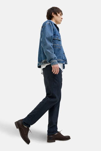 Jean chino bleu de JACK & JONES JEANS INTELLIGENCE, associé à une veste en denim et des chaussures marron, en vue latérale.