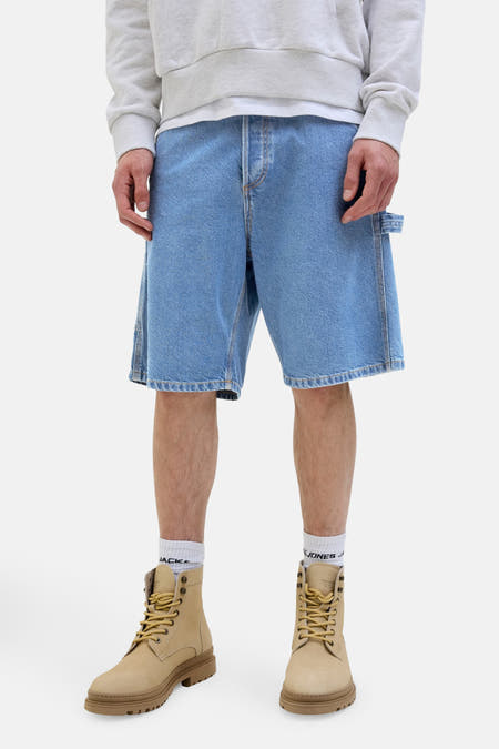 Shorts en denim bleu clair de JACK & JONES JEANS INTELLIGENCE, avec des détails de travail et associés à des bottes et des chaussettes.
