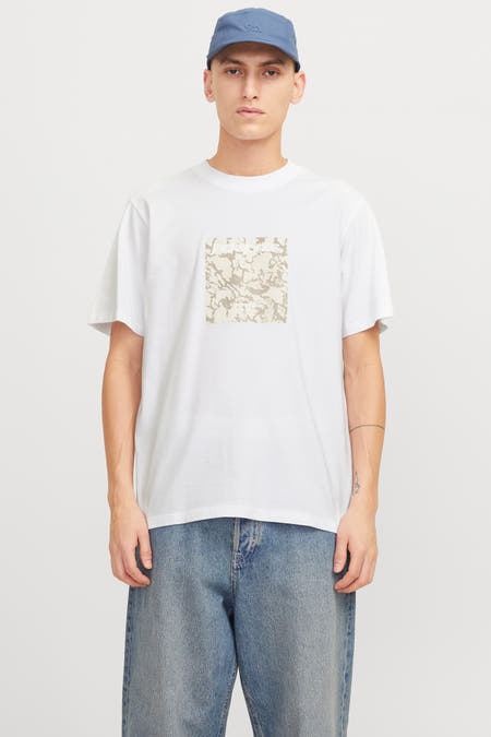 T-shirt blanc à manches courtes d'ORIGINALS BY JACK & JONES, avec un motif carré et porté avec des jeans bleus.