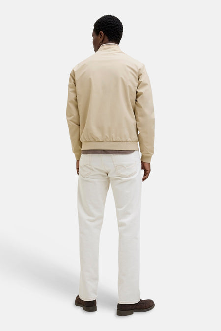 Manteau court beige de PREMIUM by JACK & JONES, vue de dos, avec bords et col côtelés, porté par un homme sur une chemise marron avec un jean blanc et des chaussures marron foncé.
