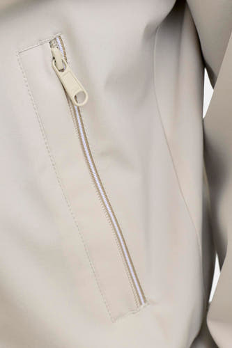 Manteau court beige de PREMIUM by JACK & JONES avec une fermeture éclair partiellement ouverte à motif rayé et un détail de logo sur la fermeture éclair.