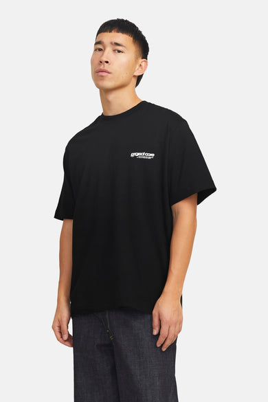 T-shirt noir à manches courtes de CORE by JACK & JONES, avec du texte blanc sur la poitrine, porté avec des jeans bleus marine.