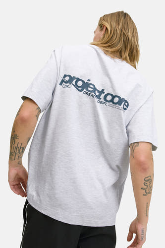 T-shirt gris à manches courtes de CORE BY JACK & JONES, avec une impression de texte bleu marine sur le dos, associé à un pantalon noir.