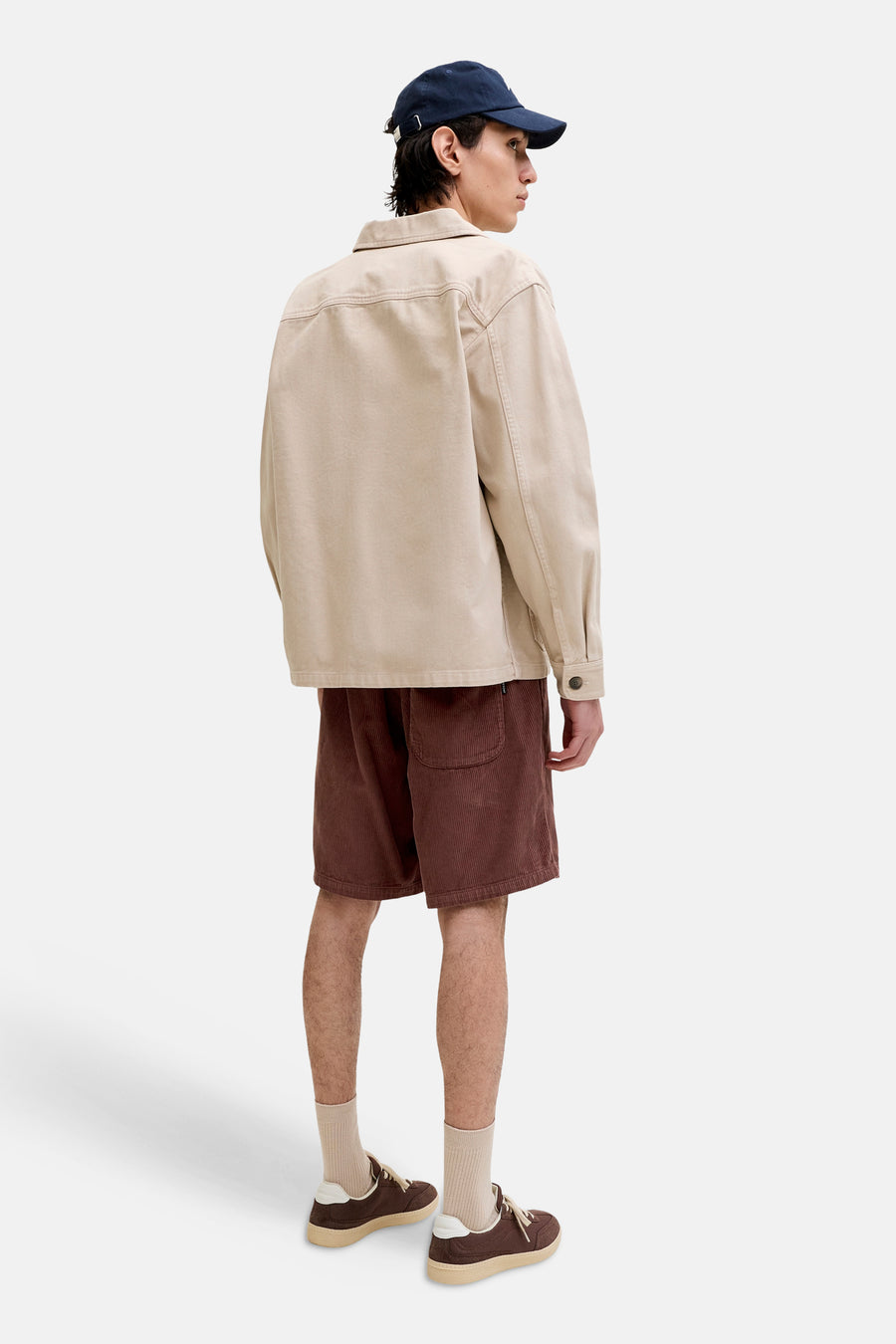 Bruine corduroy shorts van JACK & JONES JEANS INTELLIGENCE, zijprofiel, met zak, gedragen met beige overhemd en blauwe pet
