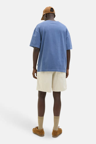 Shorts écru de JACK & JONES JEANS INTELLIGENCE, associés à des chaussures marrons, des chaussettes et un T-shirt bleu.