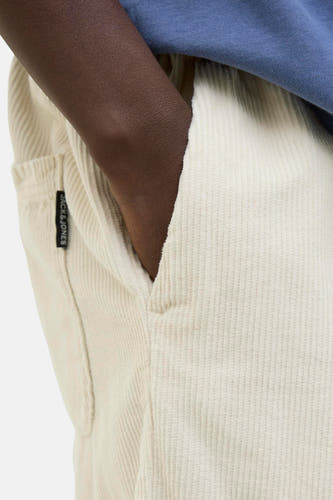 Crème court de JACK & JONES JEANS INTELLIGENCE, avec poche et peau foncée qui déborde de la poche.