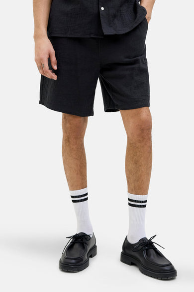 Short noir de ORIGINALS BY JACK & JONES, coupe décontractée, porté avec des chaussettes blanches et des chaussures noires.