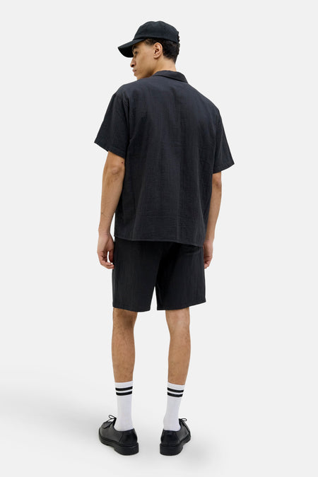 Short noir de ORIGINALS BY JACK & JONES, vu de dos, associé à des chaussettes blanches et des chaussures noires.