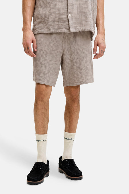 Short marron de ORIGINALS BY JACK & JONES, avec une finition texturée, porté avec une chemise, des chaussettes et des chaussures assorties.