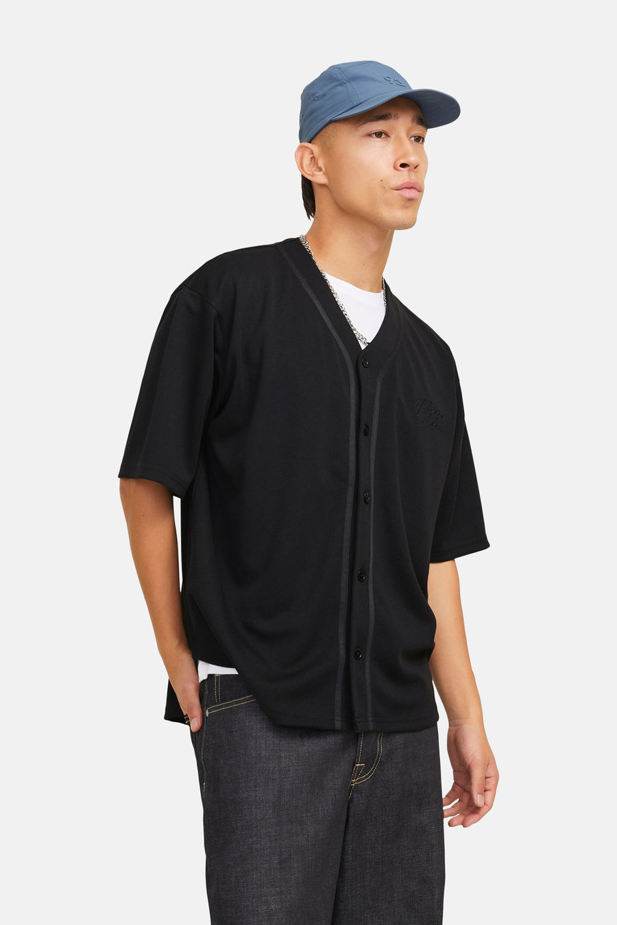 Man in zwarte baseballshirt en blauwe pet.