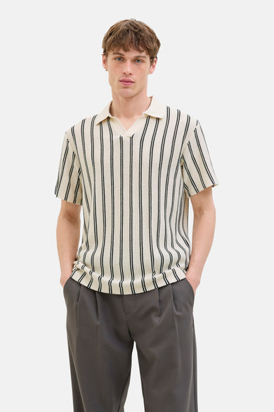 Polo beige à manches courtes de PREMIUM BLUE par JACK & JONES, avec un motif rayé vertical et un pantalon gris.