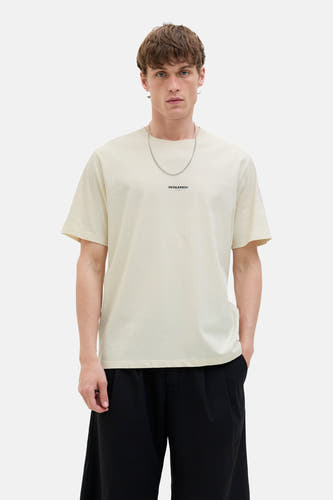 T-shirt écru à manches courtes d'ORIGINALS par JACK & JONES, avec une chaîne argentée et un pantalon noir.