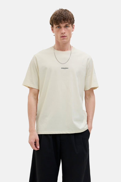 T-shirt écru à manches courtes d'ORIGINALS par JACK & JONES, avec une chaîne argentée et un pantalon noir.