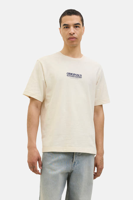 T-shirt écru à manches courtes d'ORIGINALS BY JACK & JONES, avec une impression bleue marine devant et porté avec des jeans bleu clair.