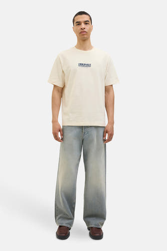 T-shirt écru à manches courtes d'ORIGINALS BY JACK & JONES, porté avec des jeans larges et des chaussures marrons.